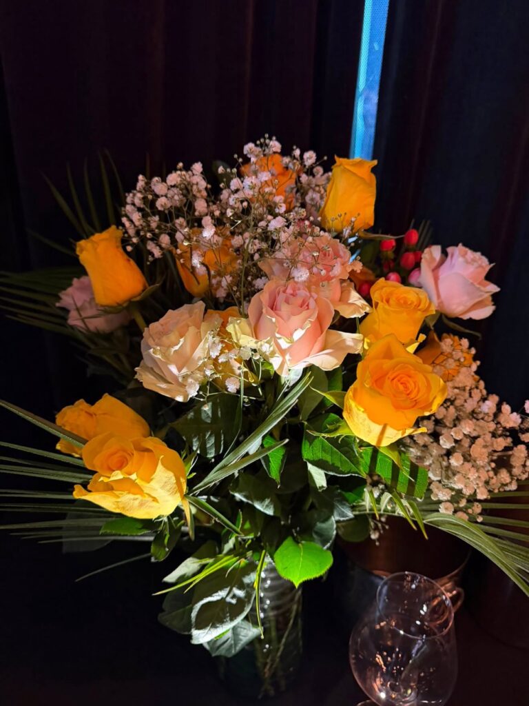 Yellow and pink rose centerpiece with baby's breath for a private event at Contadino