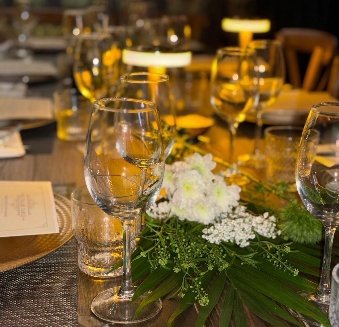 Candlelit table set with wine glasses and fresh flowers for The Italian Table wine dinner at Dal Contadino Trattoria
